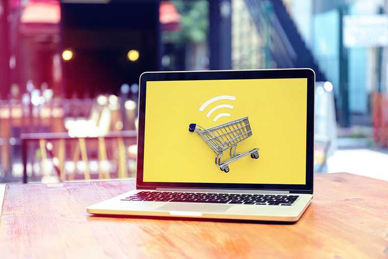 A laptop with a yellow background and a shopping cart