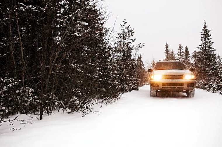 A SUV driving in forest in snow