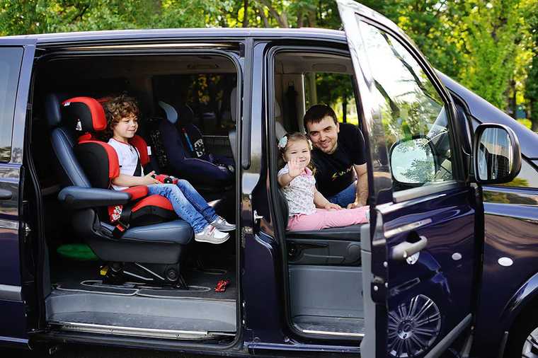 A father and two children sitting in a car