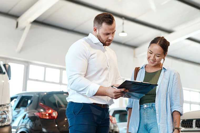 A male sale person and a customer talking in car shop