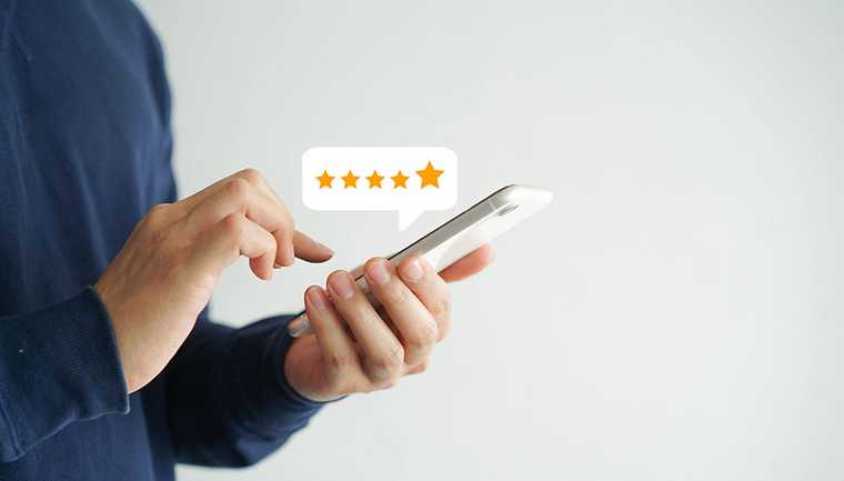 A hand holding a phone rating 5 stars