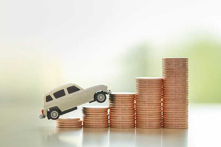 A car model climbing up stairs built up with coins