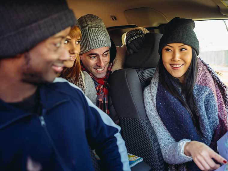 Four people sitting in a car talking